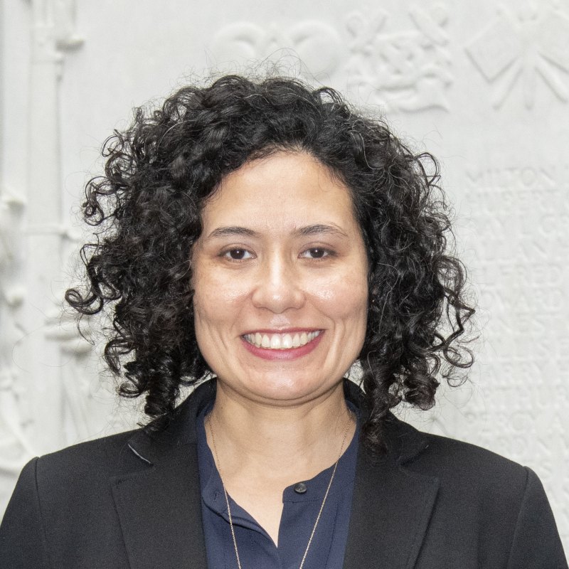 Woman with curly dark hair in a frontal headshot