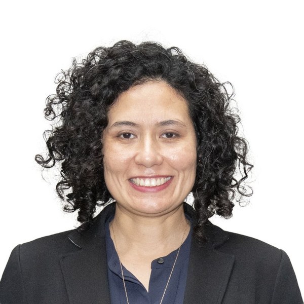 Woman with curly dark hair in a frontal headshot — ক্রপ করা